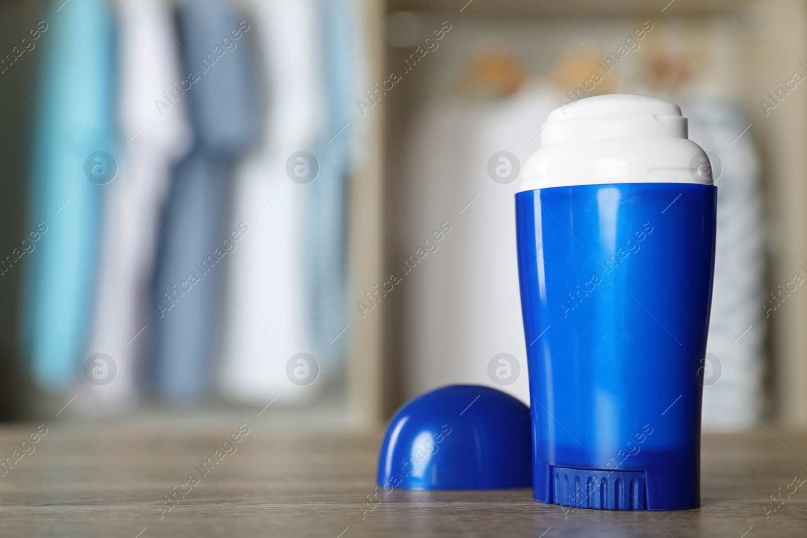 Photo of Deodorant on wooden table indoors. Space for text