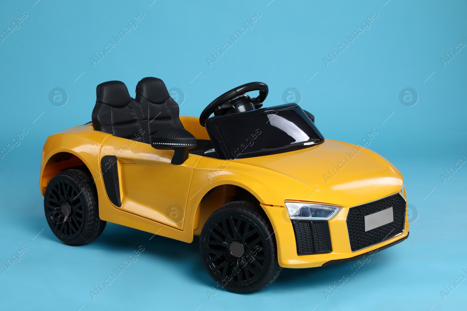 Photo of Toy yellow car on light blue background