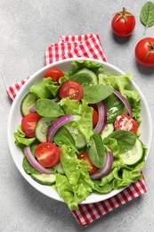 Photo of Delicious vegetable salad on light grey table, flat lay
