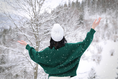 Photo of Woman wearing warm sweater in winter forest