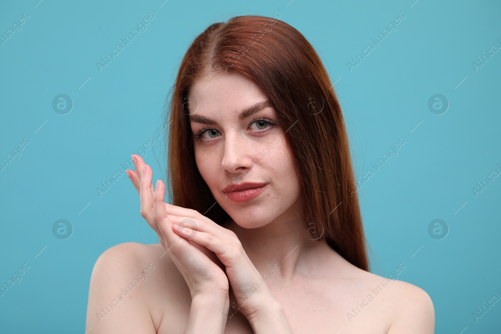 Photo of Portrait of beautiful woman with freckles on light blue background