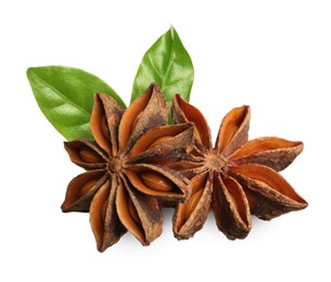 Aromatic dry anise stars and green leaves on white background