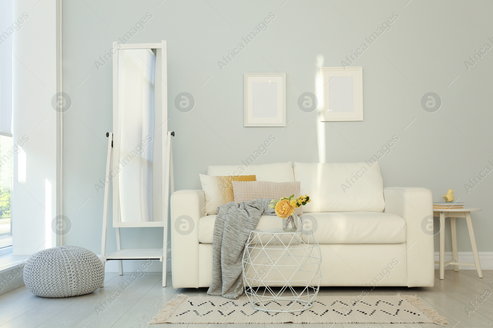 Photo of Elegant mirror near sofa in stylish living room interior