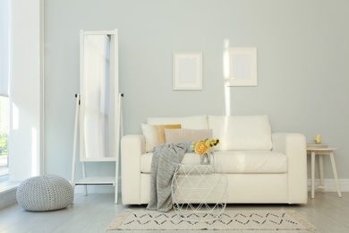 Photo of Elegant mirror near sofa in stylish living room interior