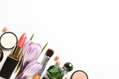 Different makeup products and flowers on white background, top view