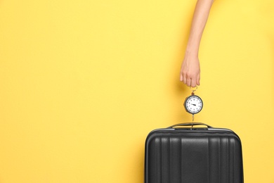 Photo of Woman weighing suitcase against color background, closeup. Space for text