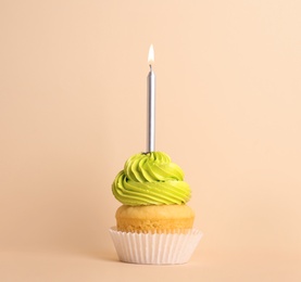 Photo of Birthday cupcake with candle on beige background