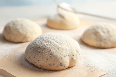 Photo of Fresh raw dough with poppy seeds and flour on table