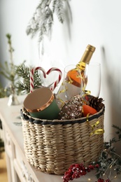 Photo of Wicker basket with gift set and Christmas decor on shelf