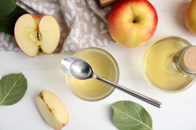 Photo of Natural apple vinegar and fresh fruits on white wooden table, flat lay