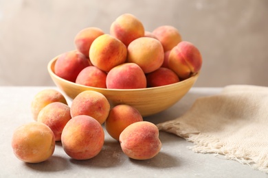 Photo of Delicious ripe peaches on table against grey background