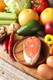 Photo of Healthy meal. Different vegetables and raw salmon on wooden table