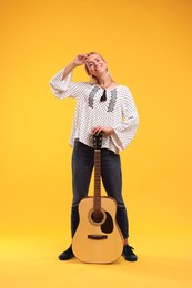 Photo of Happy hippie woman with guitar on yellow background