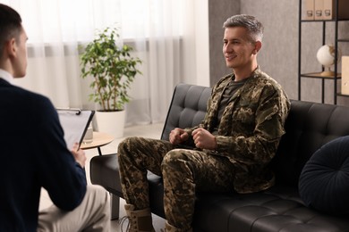 Professional psychotherapist working with military man in office