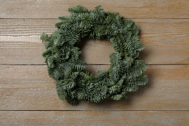 Christmas wreath made of fir tree branches on wooden background