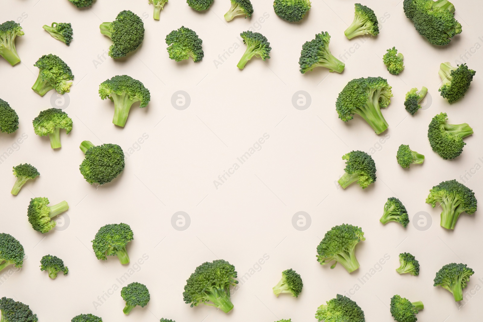 Photo of Fresh tasty broccoli on light beige background, flat lay. Space for text