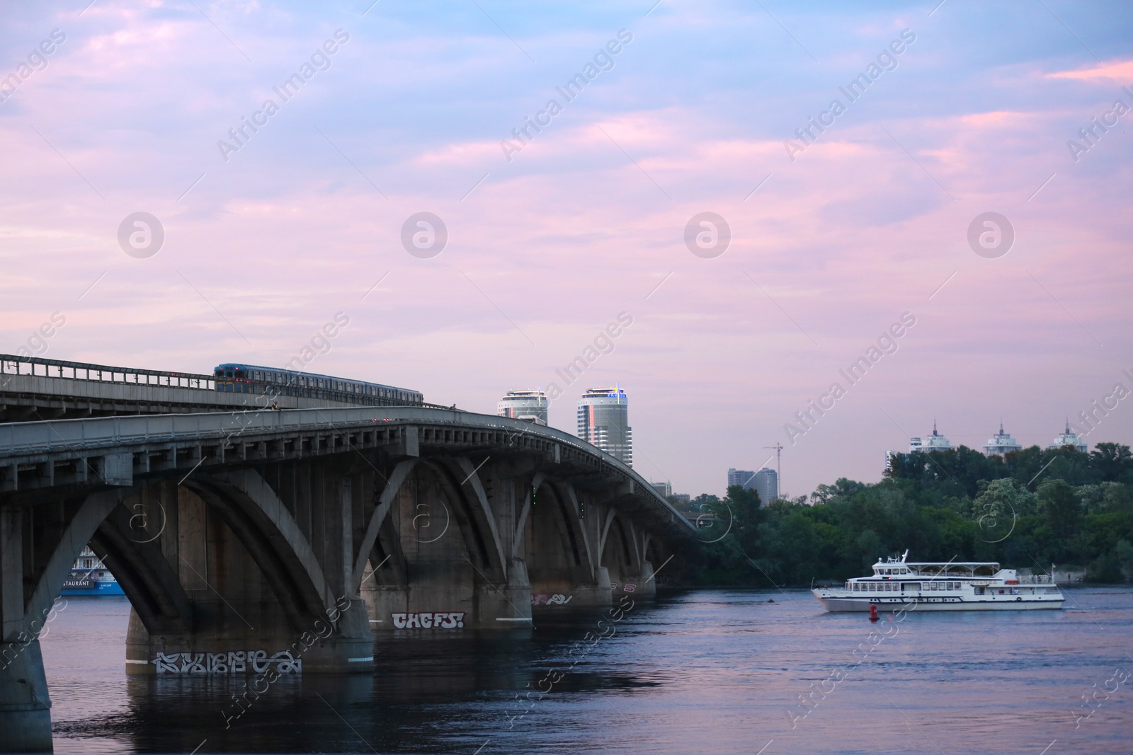 Photo of KYIV, UKRAINE - MAY 23, 2019: Beautiful view of Metro bridge over Dnipro river in evening