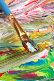 Photo of Abstract colorful acrylic paint and brush, closeup view