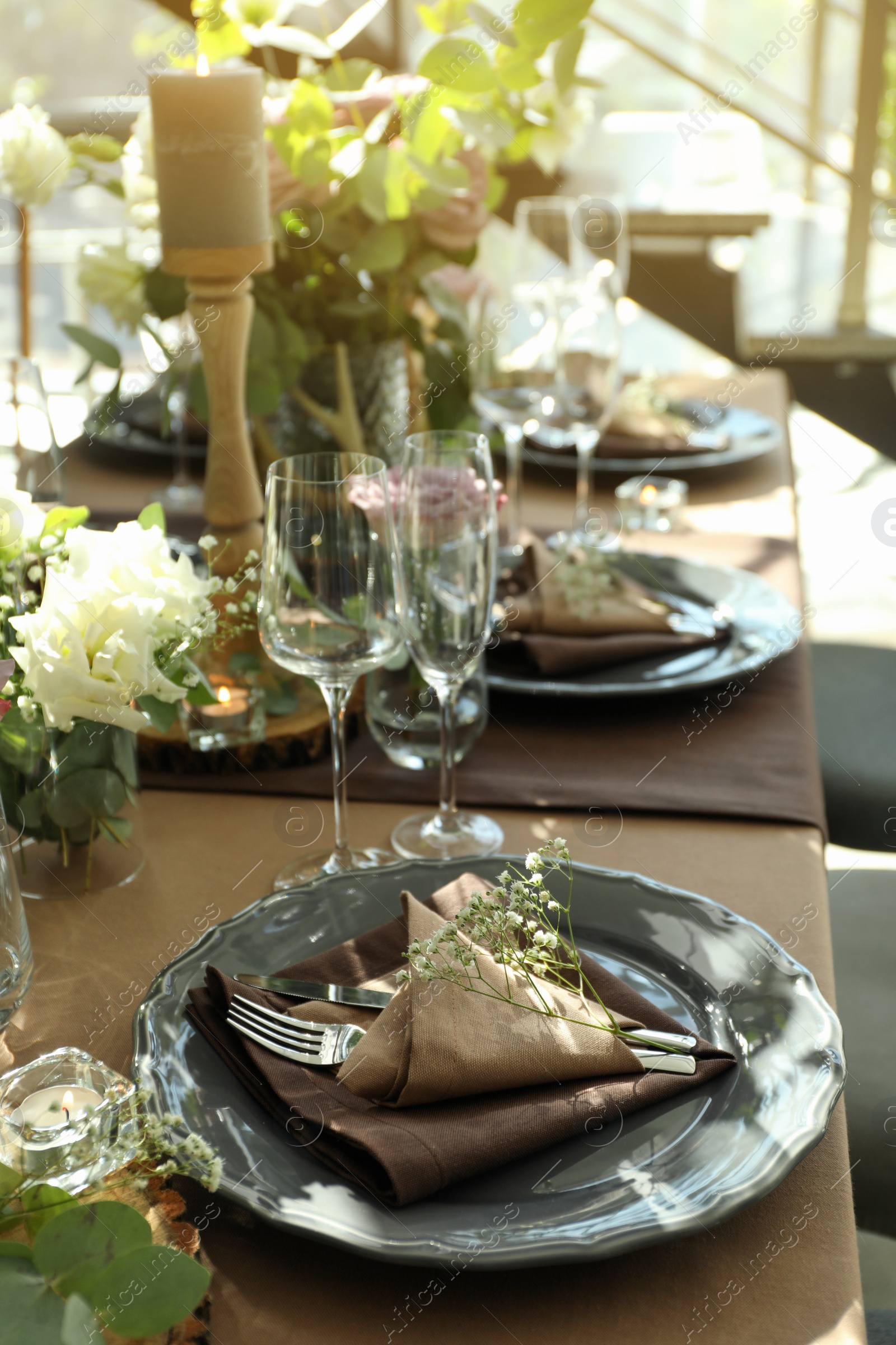 Photo of Festive table setting with beautiful tableware and floral decor in restaurant