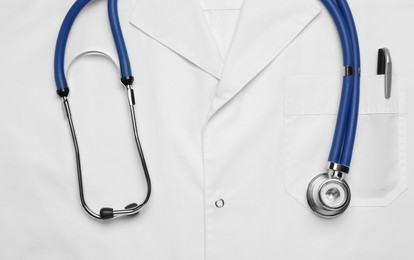 Stethoscope on white medical uniform, top view