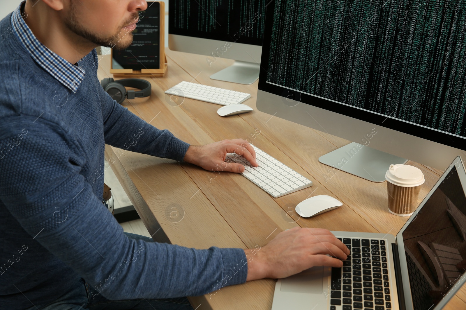 Photo of Programmer working at desk in office, closeup