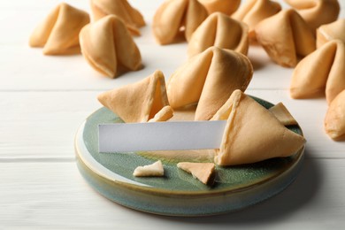 Photo of Tasty fortune cookies and paper with prediction on white wooden table, space for text