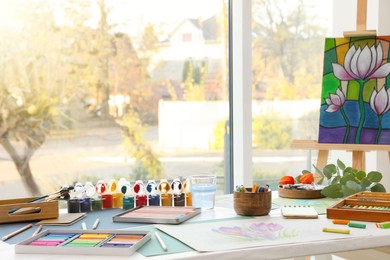 Artist's workplace with drawing, soft pastels and color pencils on table indoors