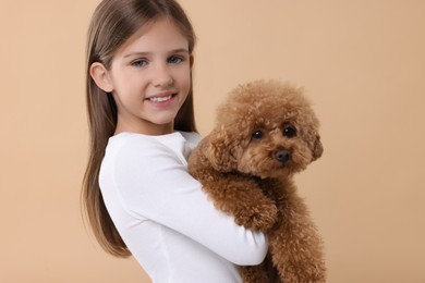 Little child with cute puppy on beige background. Lovely pet