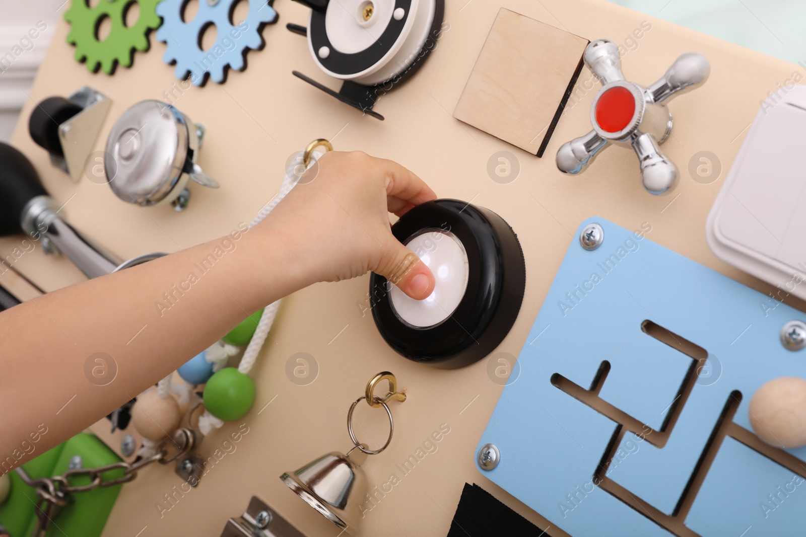 Photo of Little child playing with busy board, closeup