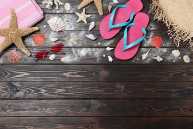 Photo of Stylish flip flops and beach objects on wooden background, flat lay. Space for text