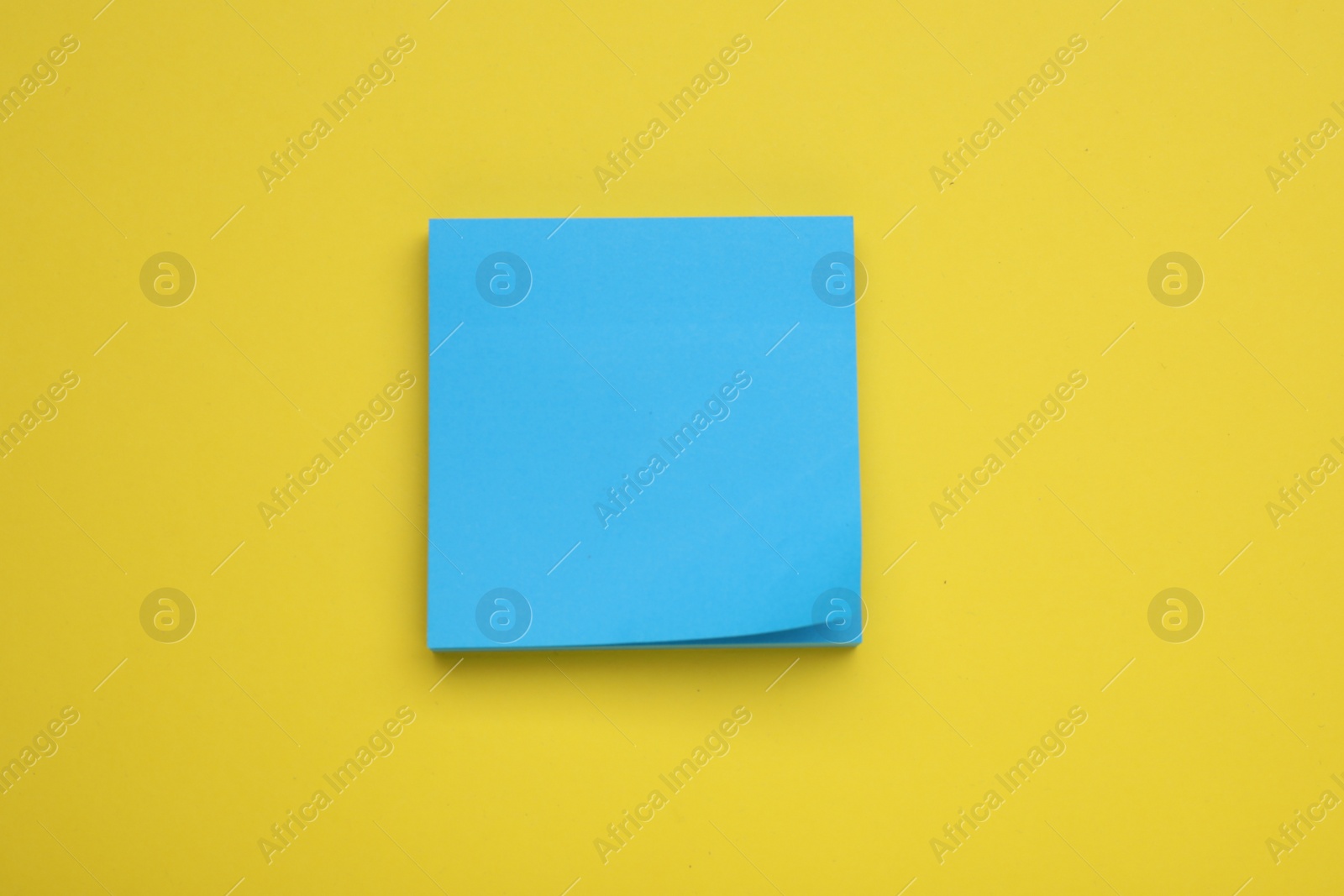 Photo of Paper note on yellow background, top view