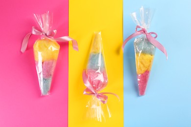 Photo of Packaged sweet cotton candies on color background, flat lay