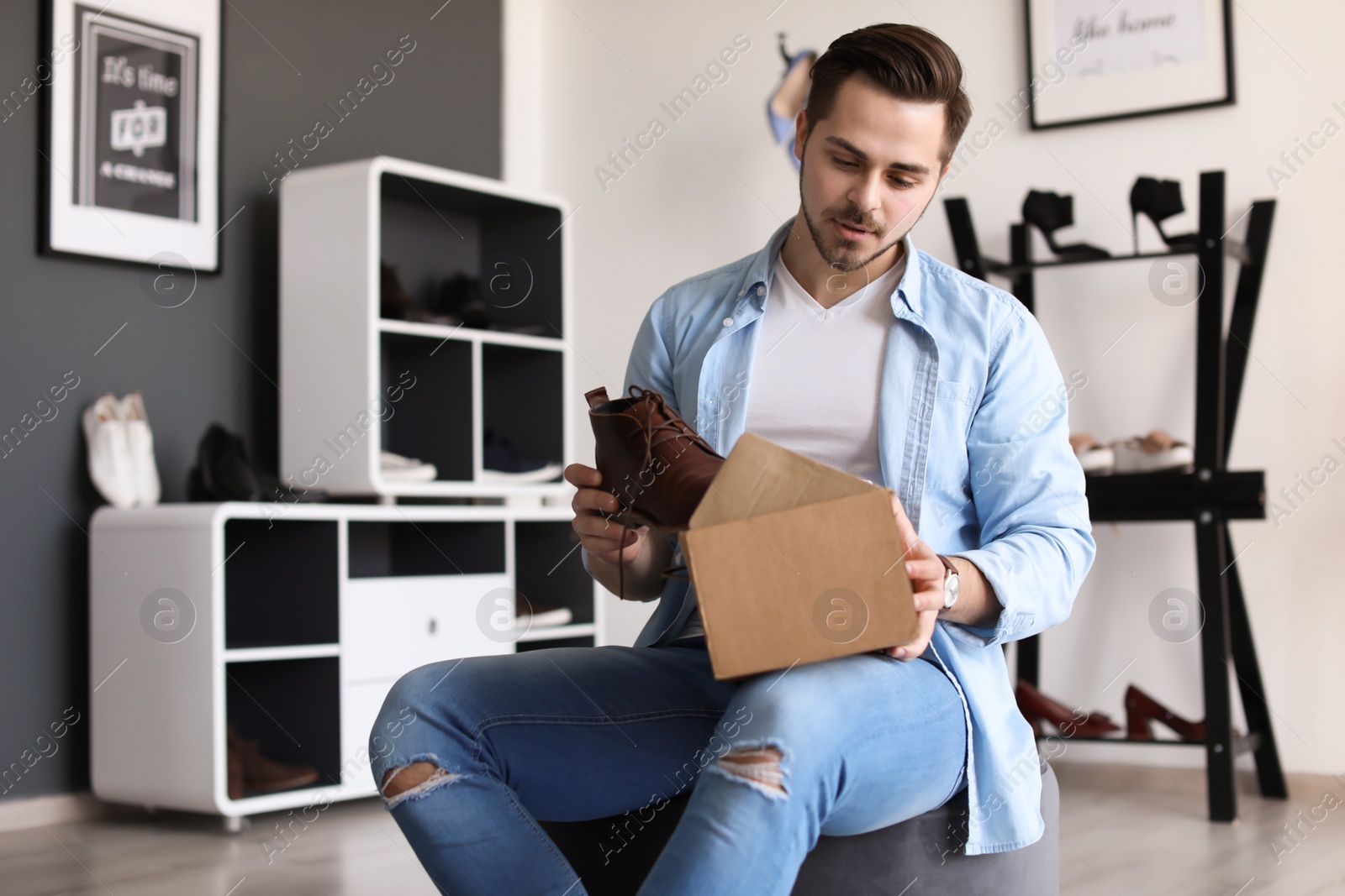 Photo of Young man choosing shoes in store