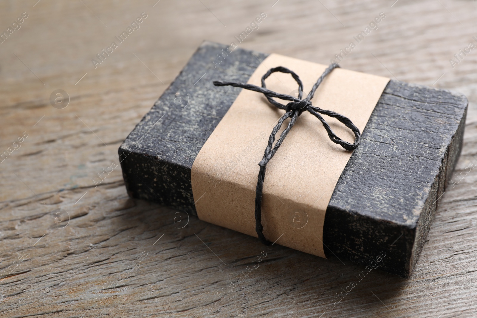 Photo of Natural tar soap on wooden table, closeup