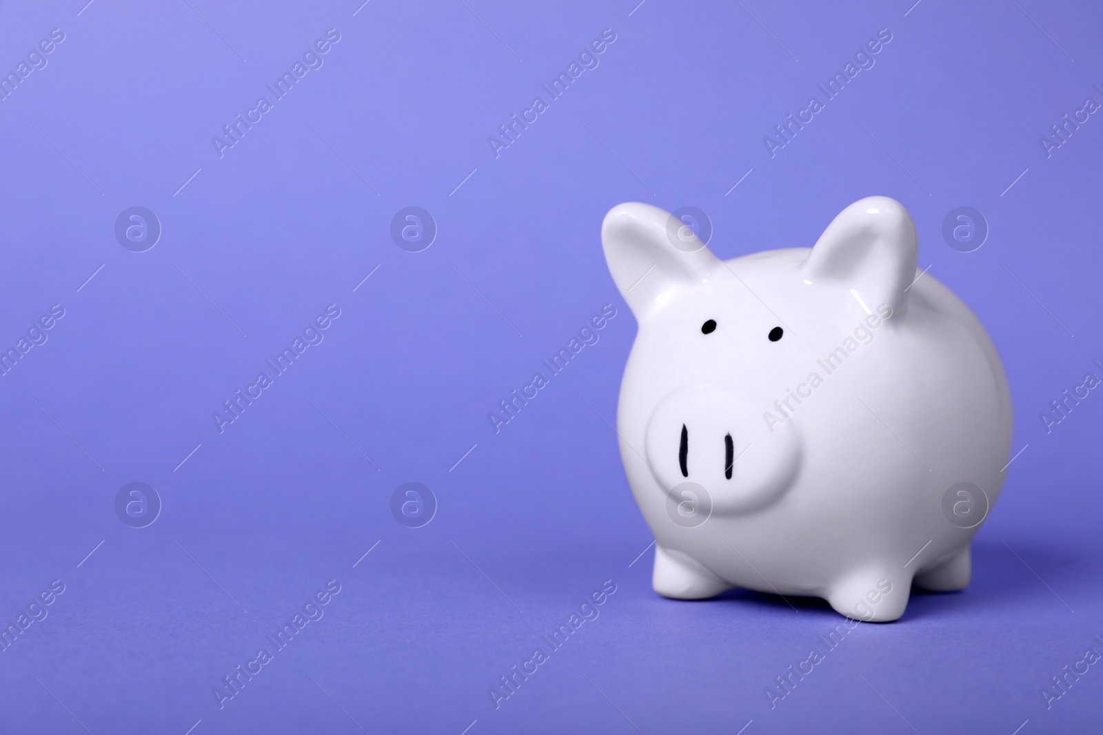 Photo of Ceramic piggy bank on purple background, space for text. Financial savings