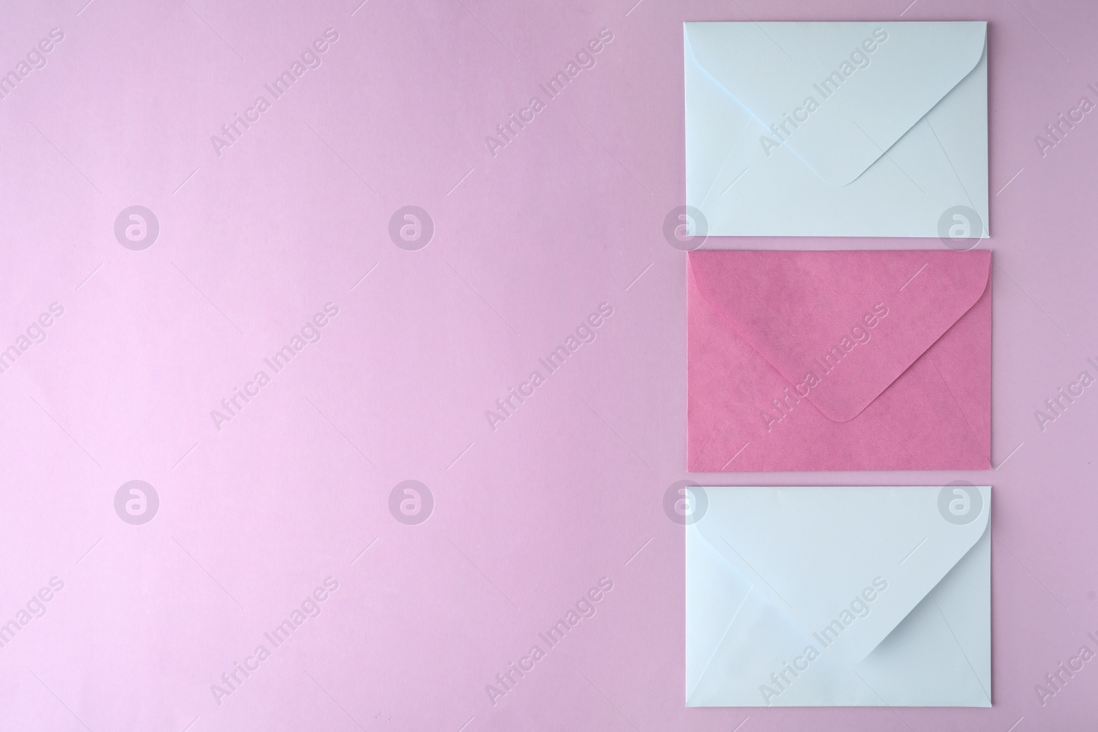 Photo of Colorful paper envelopes on pink background, flat lay. Space for text