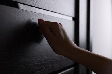 Photo of Woman knocking on door indoors, closeup view