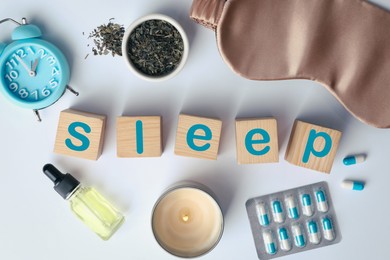 Photo of Flat lay composition with word Sleep made of wooden cubes and insomnia remedies on white background