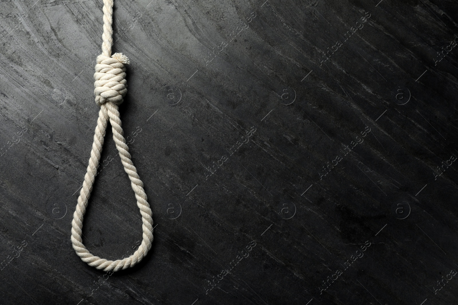 Photo of Rope noose on black table, top view. Space for text