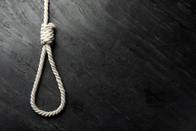 Photo of Rope noose on black table, top view. Space for text