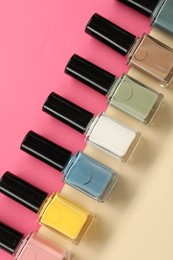 Beautiful nail polishes in bottles on color background, flat lay