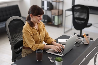 Woman watching webinar at table in office