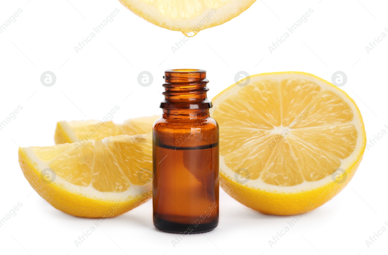 Photo of Dripping lemon essential oil into bottle isolated on white