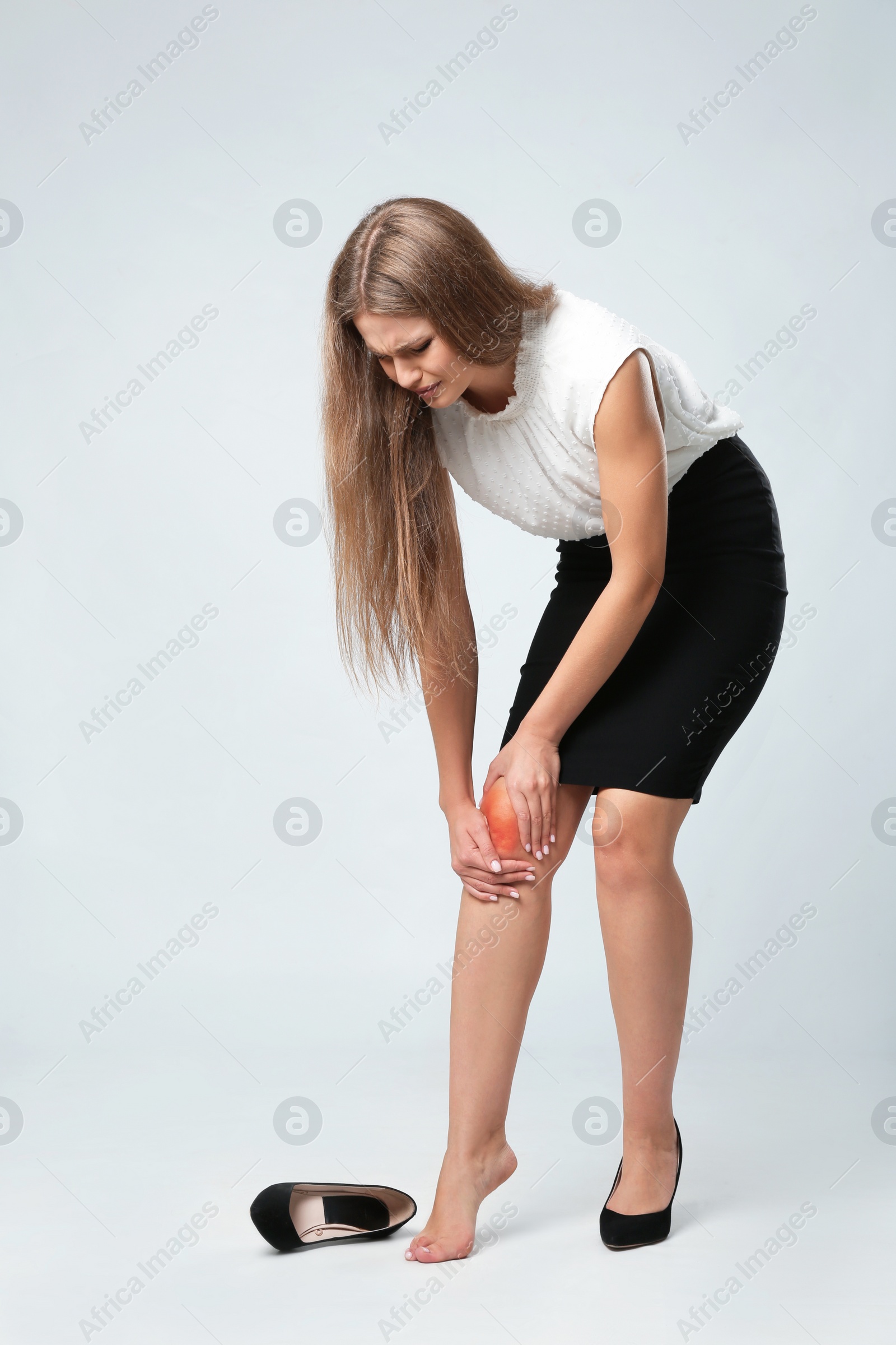 Photo of Full length portrait of businesswoman having knee problems on grey background
