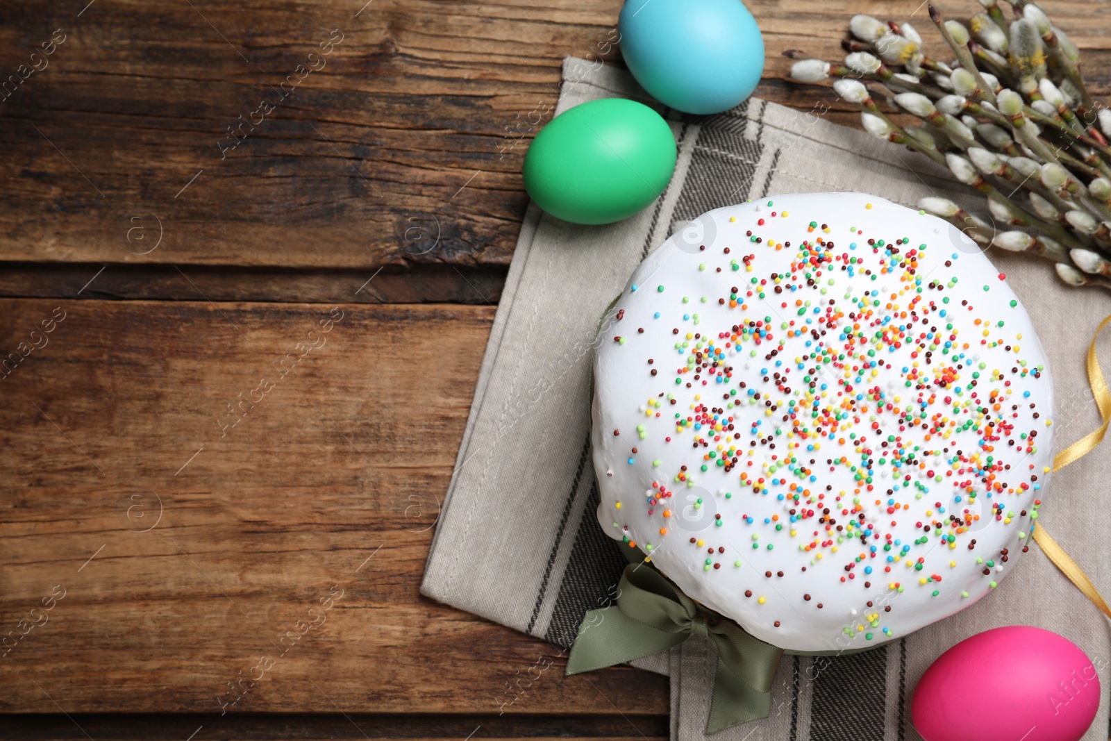 Photo of Easter cake and color eggs on wooden table, flat lay. Space for text