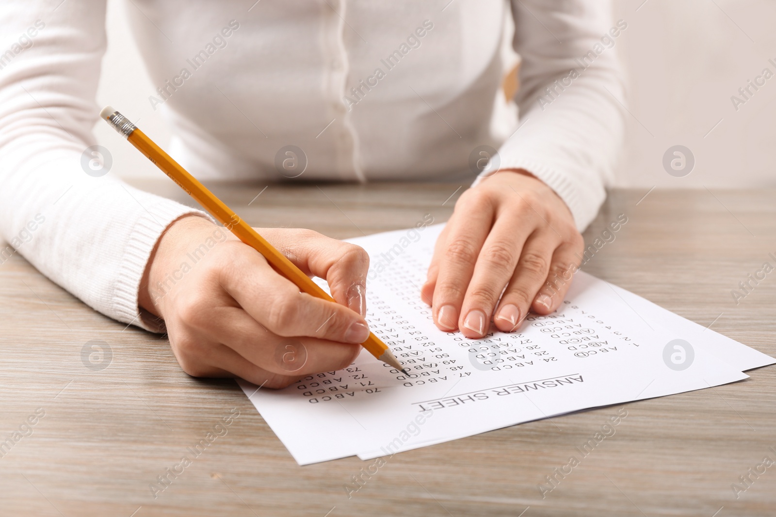 Photo of Student filling answer sheet at table, closeup