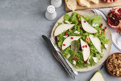 Photo of Delicious pear salad served on grey textured table, flat lay. Space for text