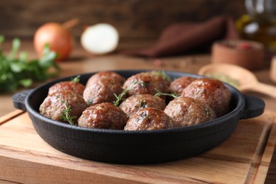 Photo of Tasty cooked meatballs served on wooden board, closeup