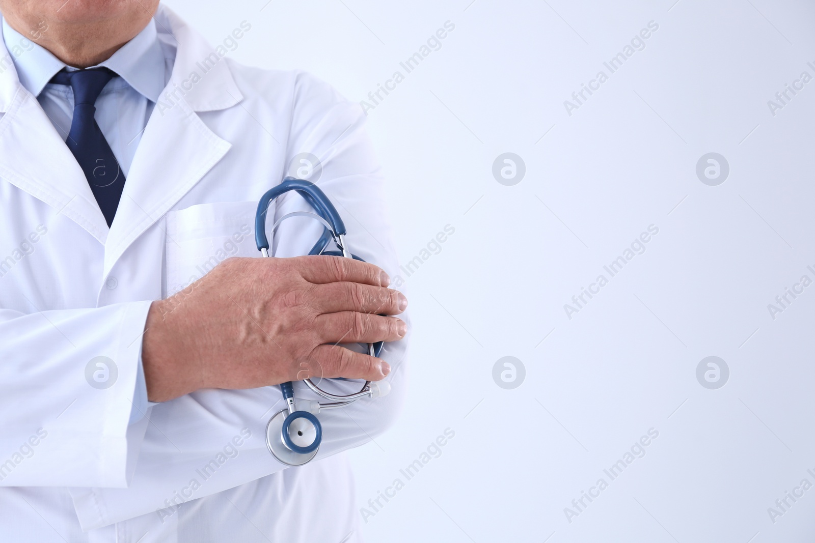 Photo of Senior doctor with stethoscope on white background, closeup