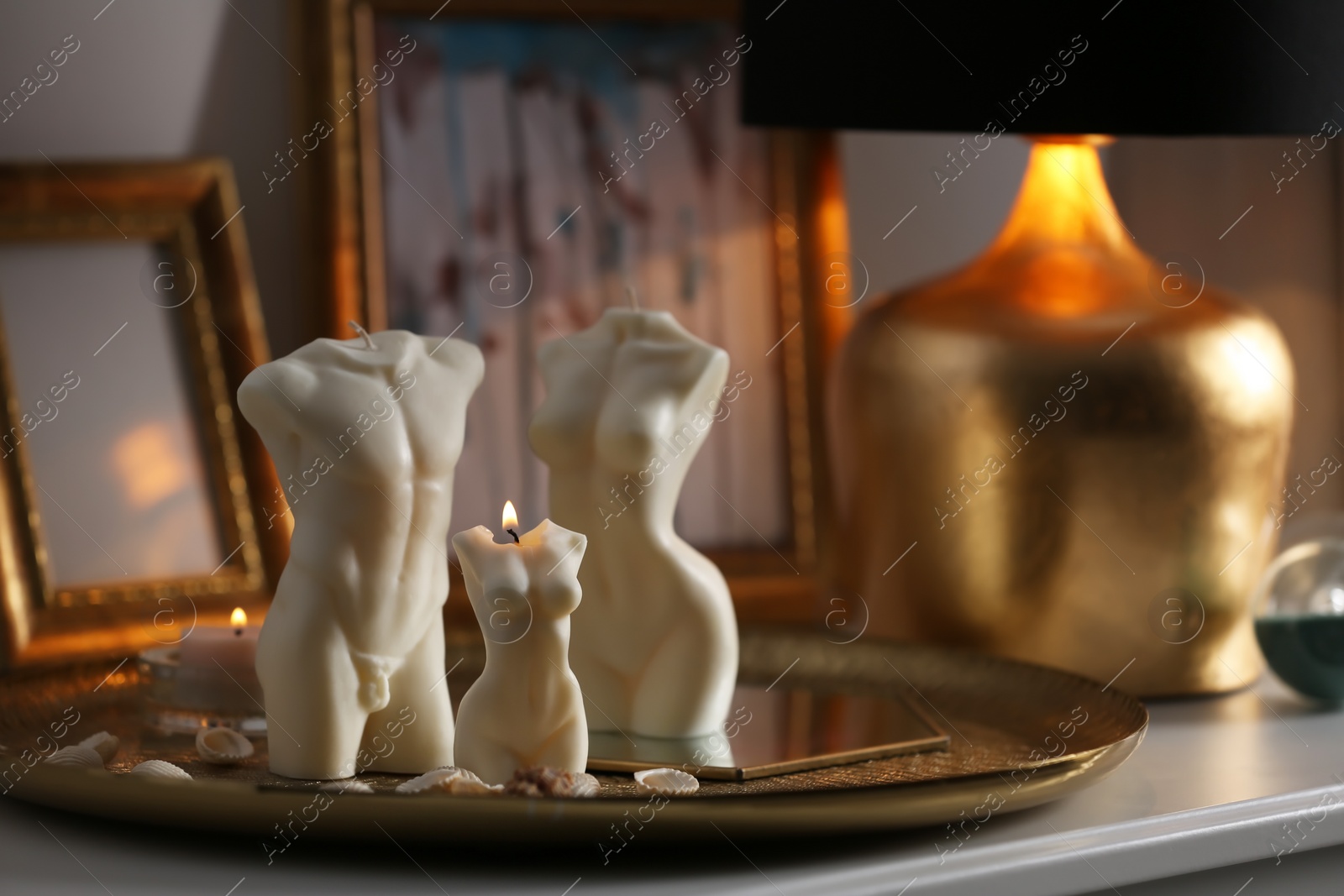 Photo of Beautiful body shaped candles on table indoors